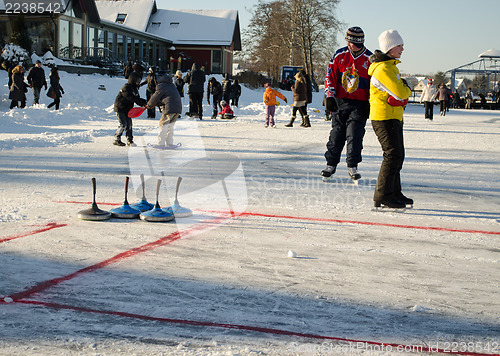 Image of people play curling eisstock skate frozen lake ice 