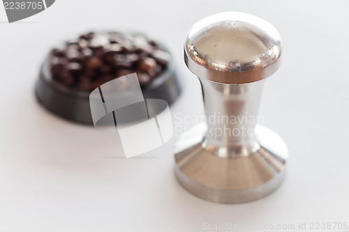 Image of Coffee tamper and middle roasted coffee bean 