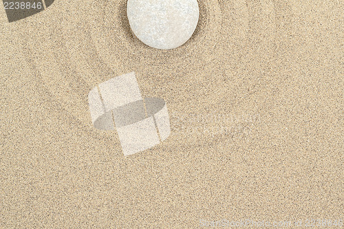 Image of zen stone in sand with circles