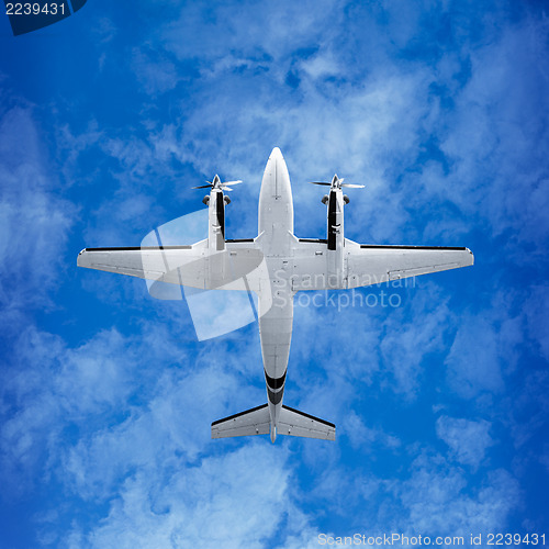 Image of Bottom view - twin prop airplane on sky background