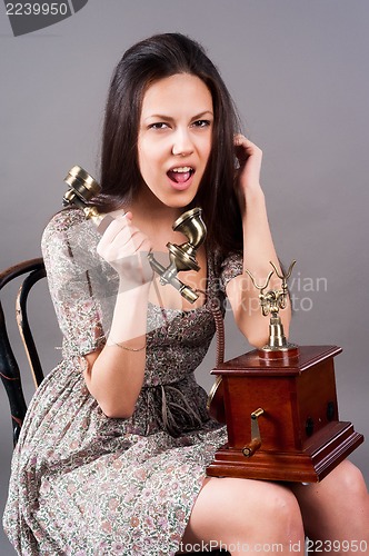 Image of Attractive woman calling by retro phone