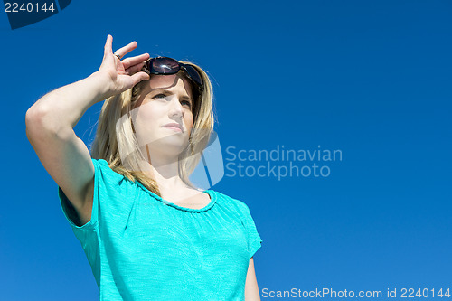 Image of Woman raising sunglasses