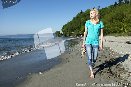 Image of Woman walking on beach