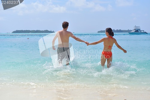 Image of happy young couple have fun on beach