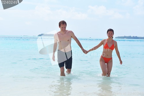 Image of happy young couple have fun on beach