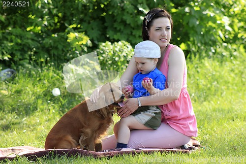 Image of Mother, child and dog on picnic