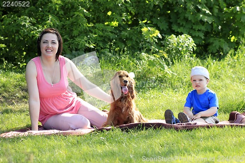 Image of Mother, child and dog on picnic