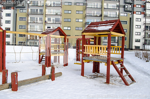 Image of playground wooden red houses swing rope winter  