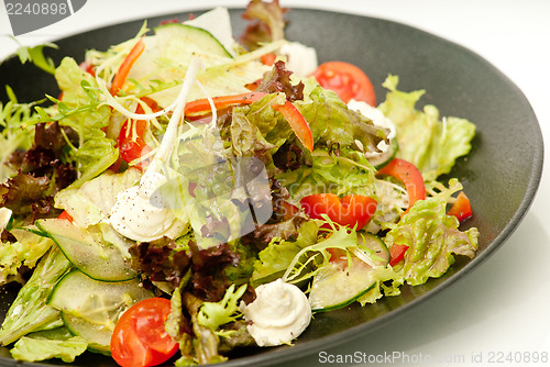 Image of Healthy green salad on the black plate