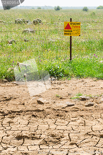 Image of Desert dried land and quiet green mines field