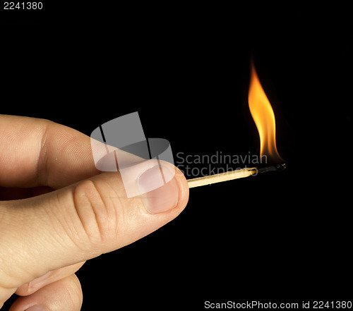 Image of Hand holding burning match stick