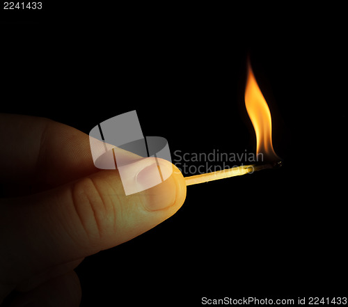 Image of Hand holding burning match stick