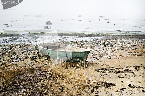 Image of Old fishing boat at coast foggy in the morning