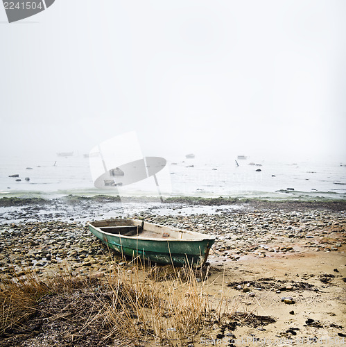 Image of Old fishing boat at coast foggy in the morning