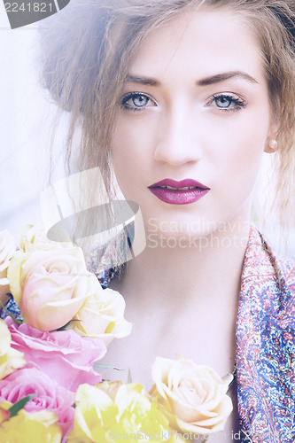 Image of attractive young woman with pink roses