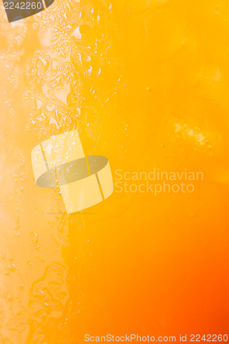 Image of Fizzy glass of iced orange juice up close 