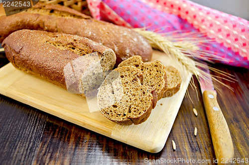Image of Rye baguettes with a knife and a wicker basket