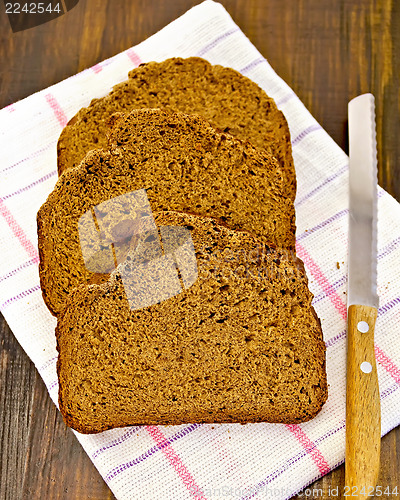 Image of Rye bread slices with a knife on a napkin