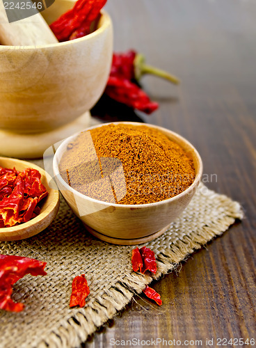 Image of Peppers red in a wooden utensil on sacking