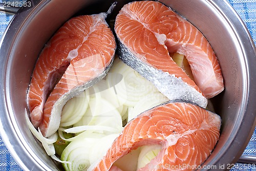 Image of raw salmon and onions in pot