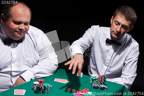 Image of Two gentlemen in white shirts, playing cards