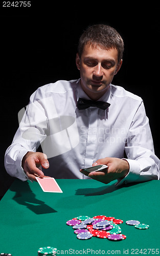 Image of Gentleman in white shirt, playing cards