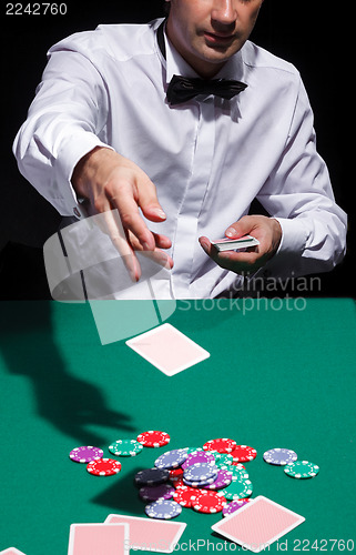 Image of Gentleman in white shirt, playing cards