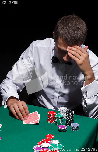 Image of Gentleman in white shirt, playing cards