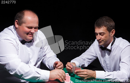 Image of Two gentlemen in white shirts, playing cards