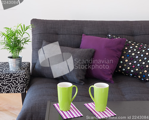 Image of Sofa with bright cushions and green cups on a table