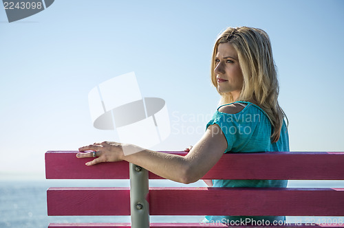 Image of Young Woman Sitting on a Bench, at the sea side