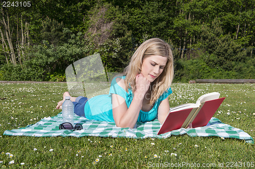 Image of Young Woman Reading Book In Park