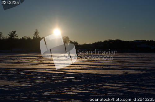 Image of people silhouette  frozen lake snow sunset evening 