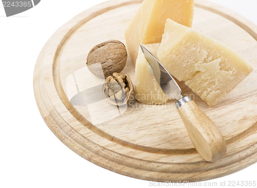 Image of Nuts and cheese on wooden board.