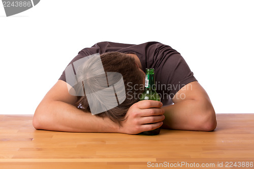 Image of Man sleeping on a table with beer