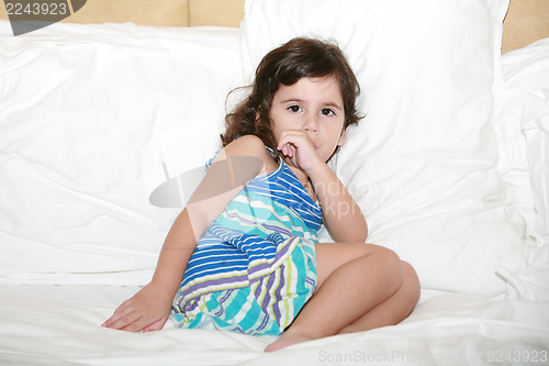 Image of Beautiful baby girl sucking her thumb just before bedtime 