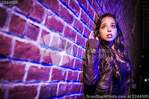 Image of Frightened Pretty Young Woman Against Brick Wall at Night