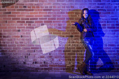 Image of Mixed Race Woman Holding Her Hand Out Against Brick Wall