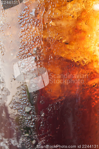 Image of Fizzy cola in a glass with ice cubes