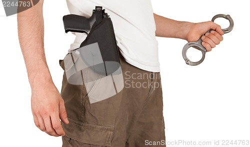 Image of Close-up of a man with a gun and handcuffs