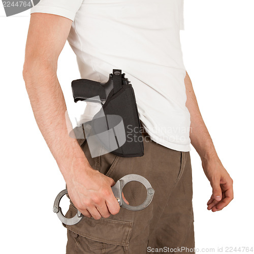 Image of Close-up of a man with a gun and handcuffs