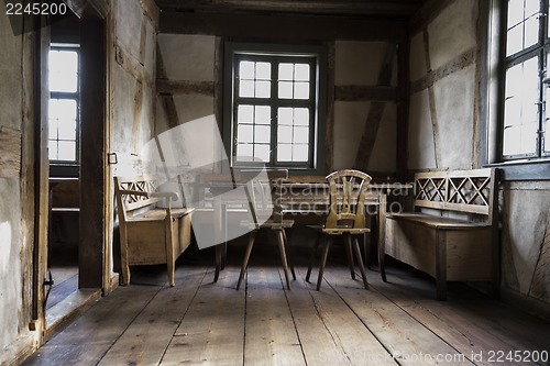 Image of rustic chamber with bench, table and chair.