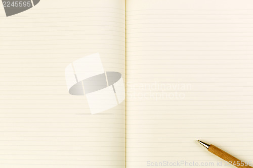 Image of Wooden ballpoint pen on open notebook