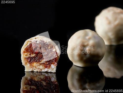 Image of dried nuts and raisins candies covered with white chocolate