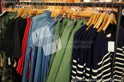 Image of Fashion clothing on hangers in a shop