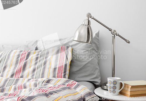 Image of Lamp and books on a side table near bed