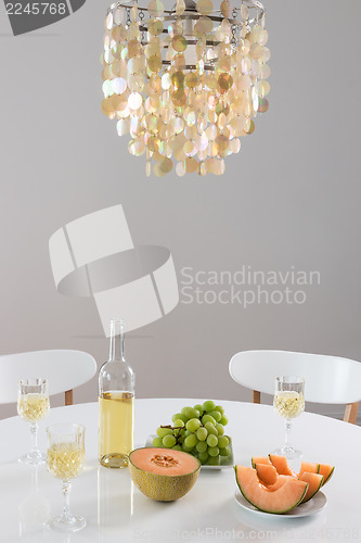 Image of Decorative chandelier and table setting with wine