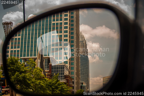 Image of buildings seen in side mirror