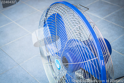 Image of Turn off industrial fan on blue floor