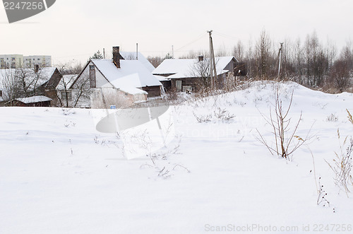 Image of old wooden houses with abundant snowy rooftops  